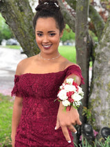 XO Babe Jayden ready for prom in her burgundy off the shoulder prom dress. She is stretching out her arm to show off her white and red flowered corsage